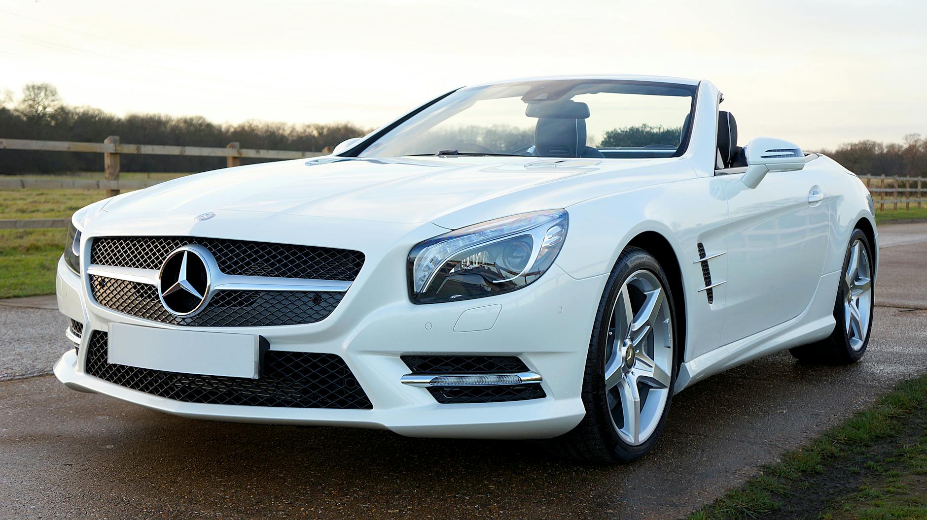 Białe cabriolet Mercedesa na malowniczej wiejskiej drodze w Wielkiej Brytanii