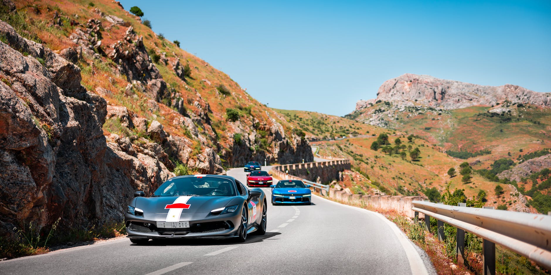 Dwa sportowe auta jadą górską drogą podczas dziennego testu