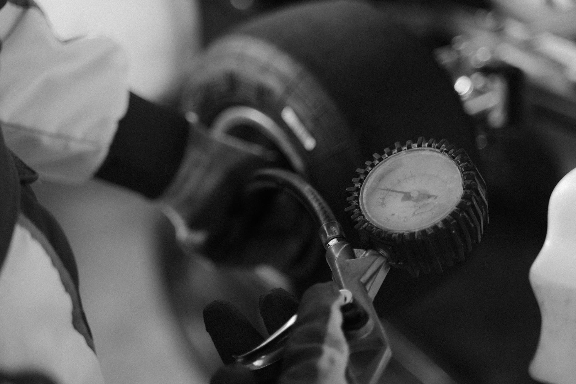 Mechanik mierzy ciśnienie w oponie gokarta za pomocą manometru