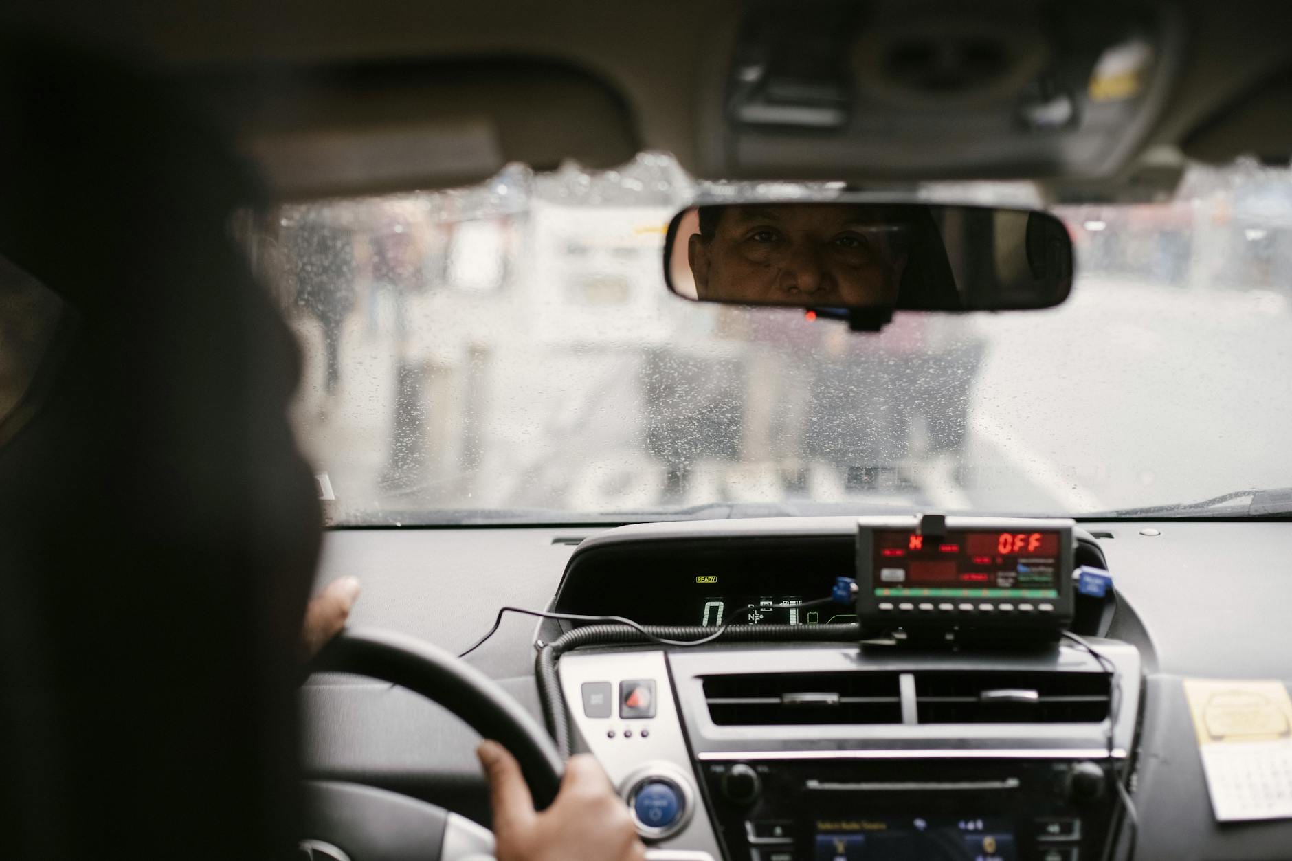Mężczyzna w lusterku wstecznym prowadzi auto w miejskim korku