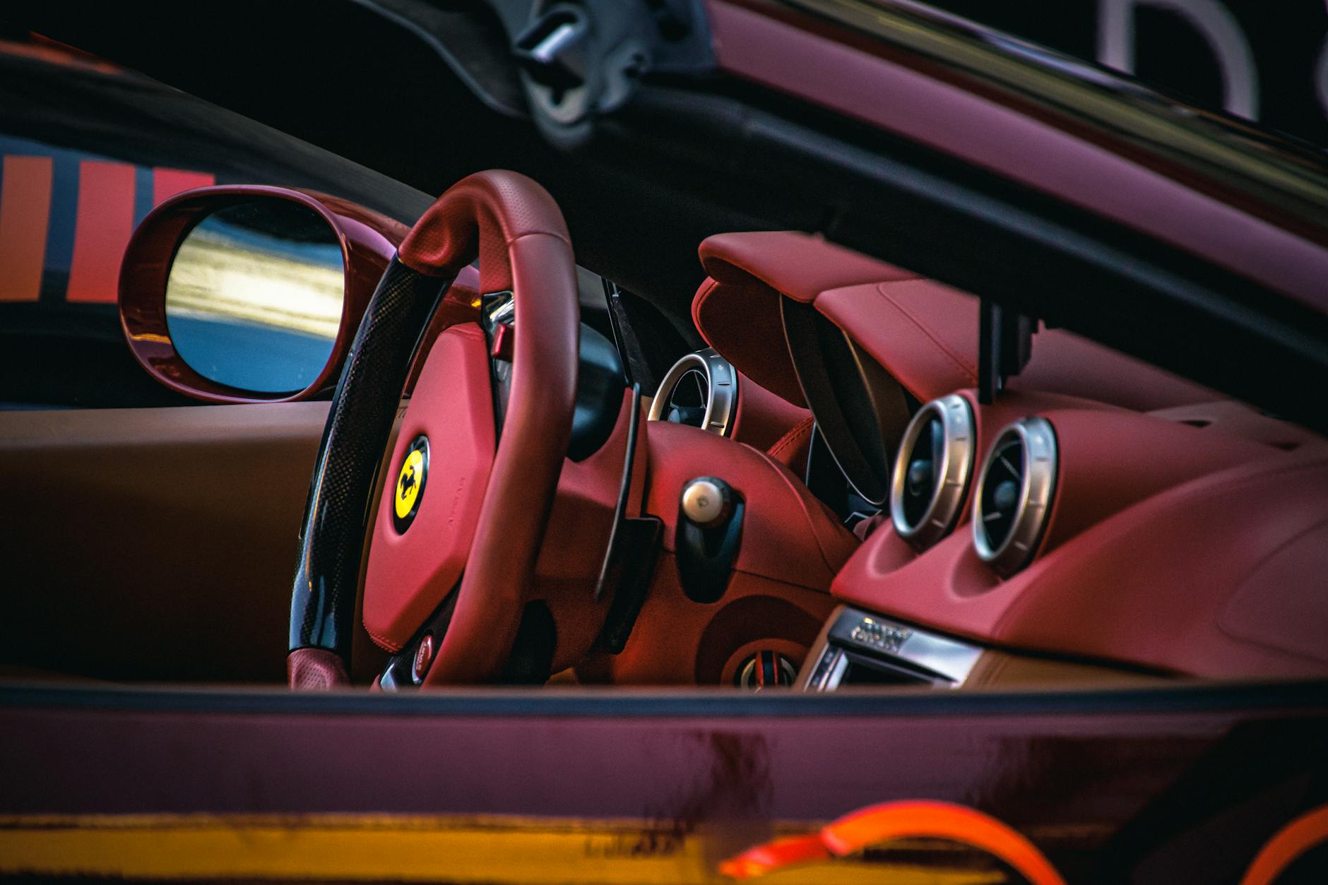 Jak poprawnie trzymać kierownicę w sportowej jeździe? Wnętrze sportowego auta z czerwonymi fotelami i kierownicą