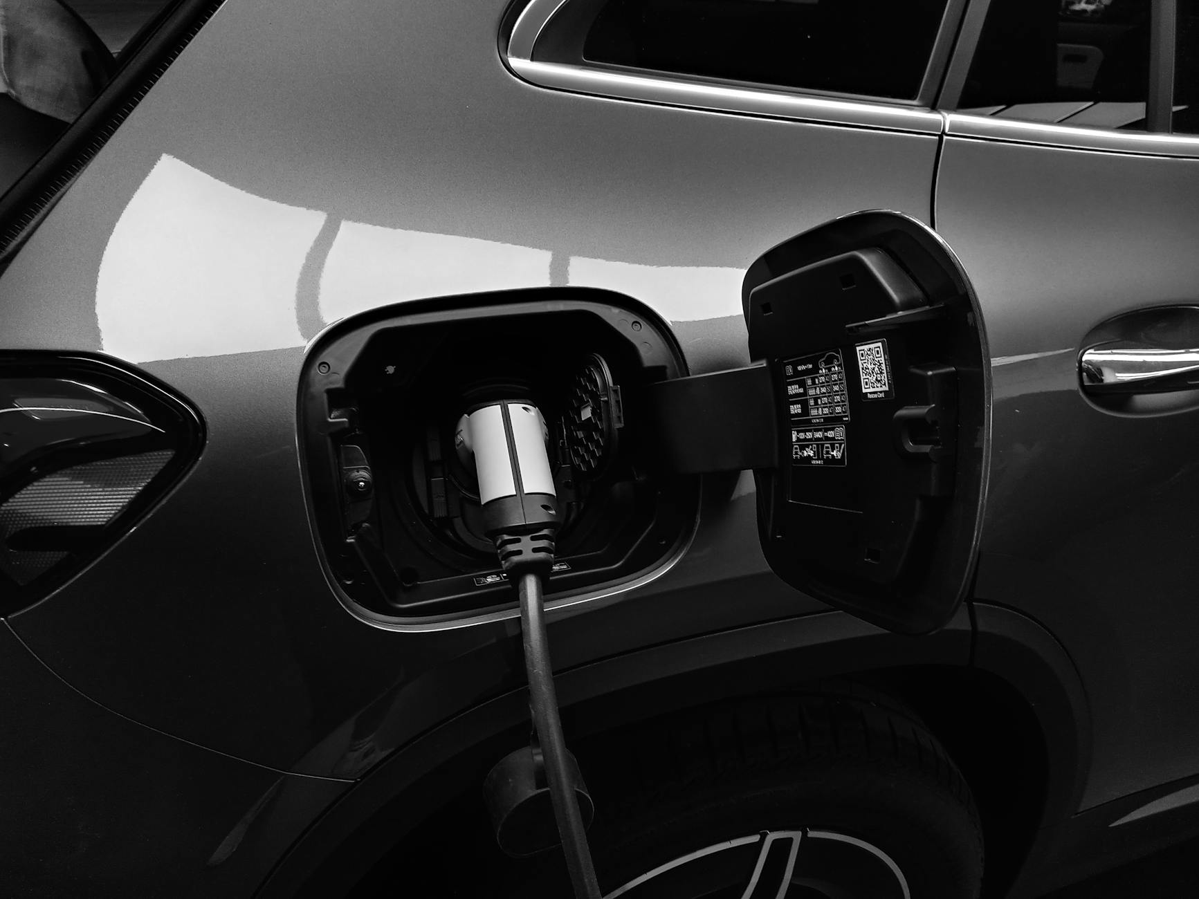 Zbliżenie na kabel ładujący podłączony do gniazda auta elektrycznego