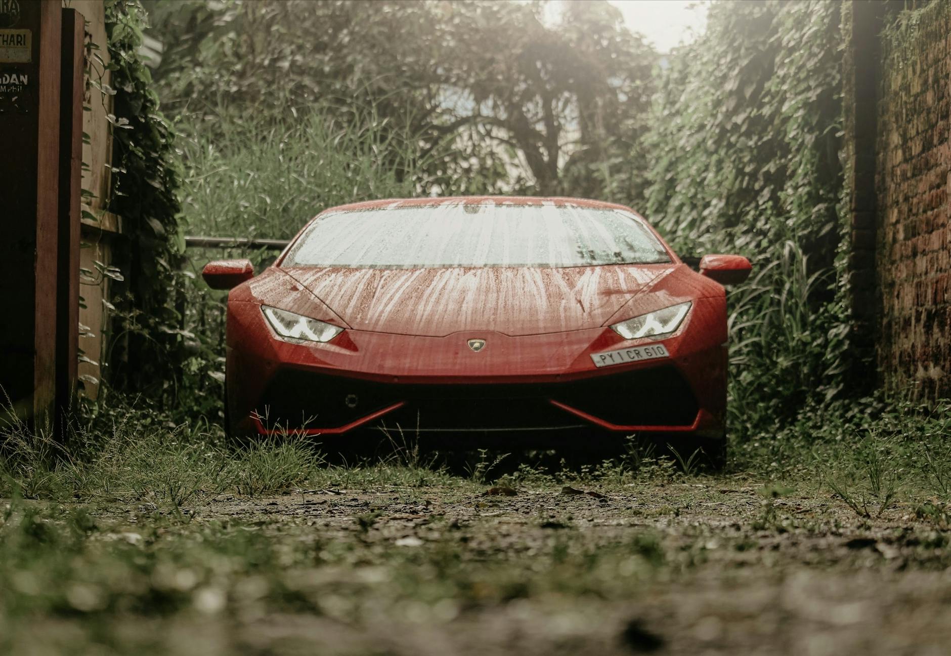 Czerwone sportowe auto zaparkowane w deszczu we włoskim miasteczku