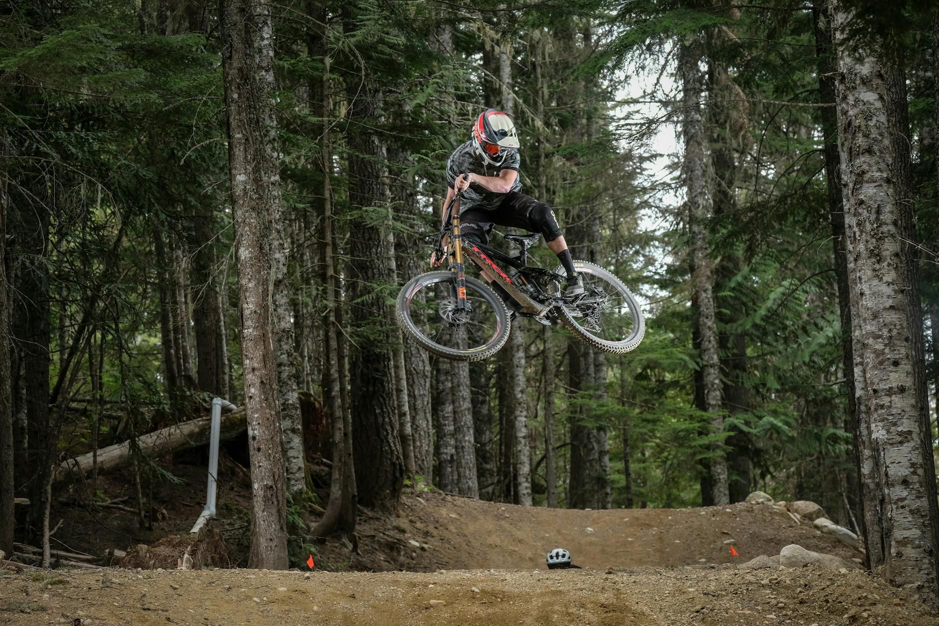 Kolarz górski wykonujący wysoki skok na leśnym singletracku