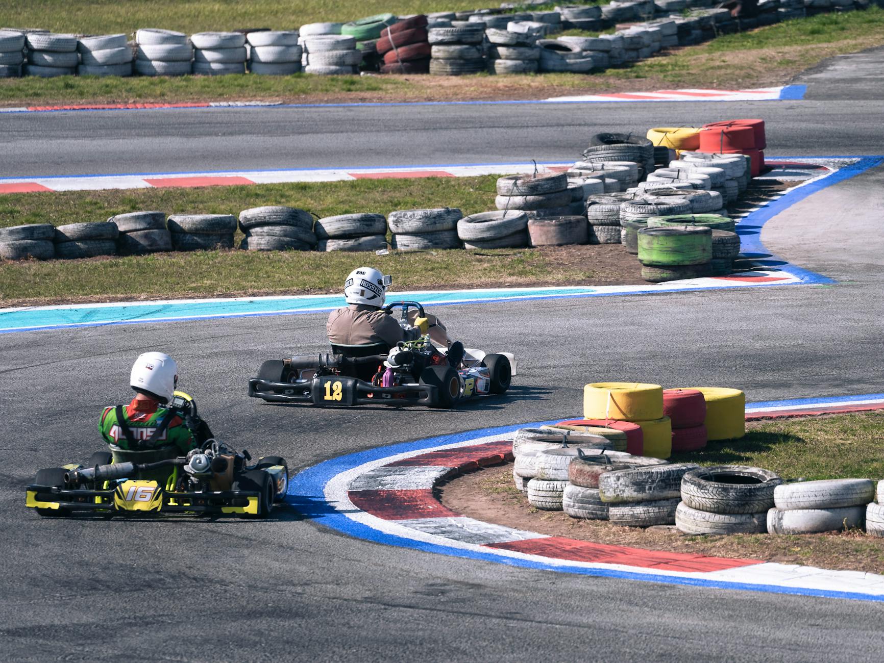 Wyścig gokartów na zewnętrznym torze, kierowcy pokonują szybki zakręt