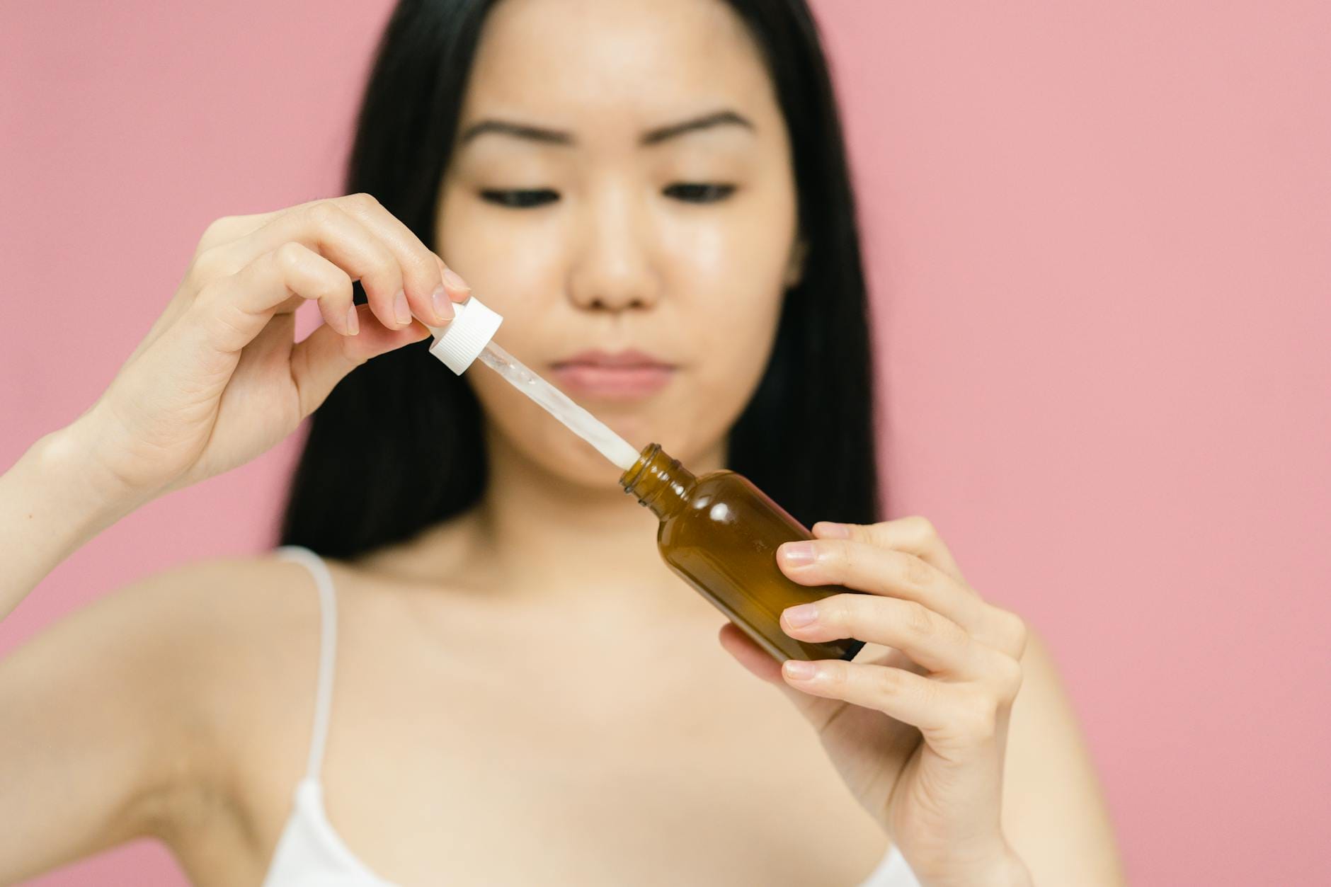Zbliżenie na kobietę trzymającą pipetę z naturalnym serum do twarzy