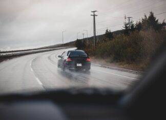 Jak opanować aquaplaning przy dużej prędkości na autostradzie? Czarny samochód na mokrej autostradzie podczas